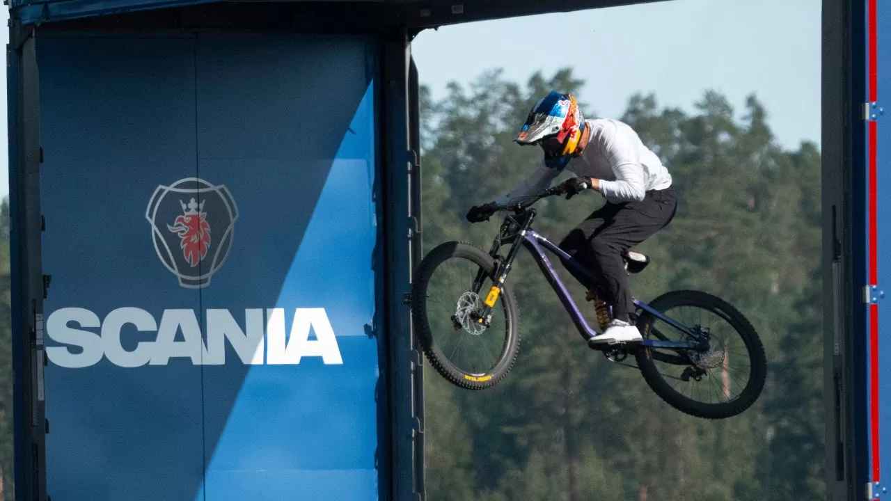 Matt Jones salta de bicicleta por estrutura entre dois caminhões autônomos da Scania em evento da Red Bull